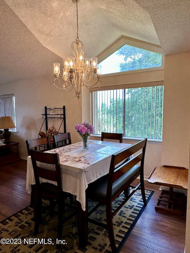 dining room featuring a textured ceiling, lofted ceiling, a chandelier, and dark wood-type flooring