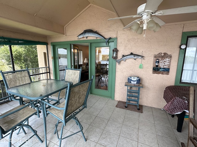 sunroom / solarium featuring a healthy amount of sunlight, ceiling fan, and vaulted ceiling