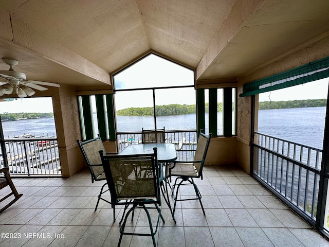 sunroom featuring ceiling fan, a healthy amount of sunlight, and a water view