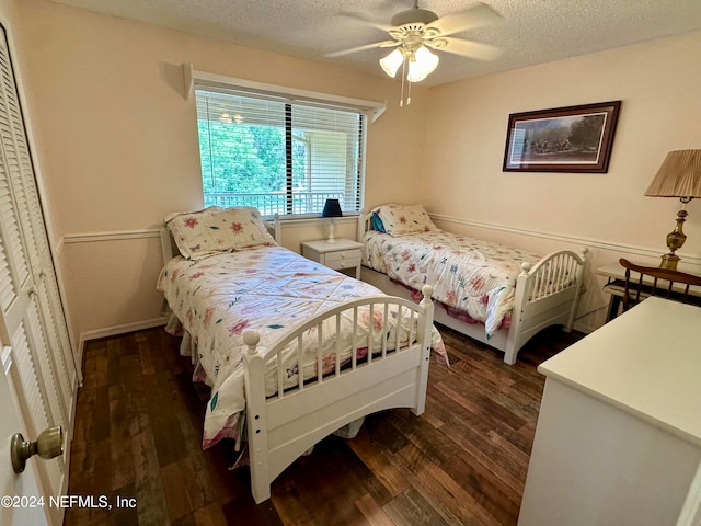 bedroom with dark hardwood / wood-style floors, ceiling fan, a closet, and a textured ceiling