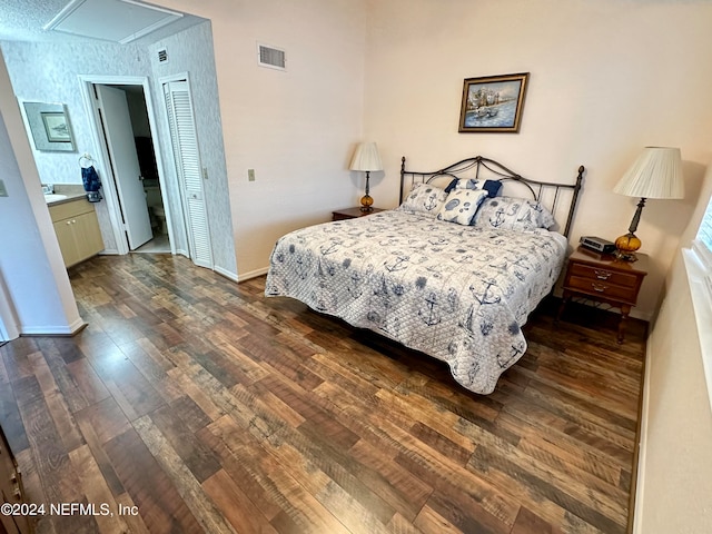 bedroom with dark wood-type flooring and ensuite bathroom