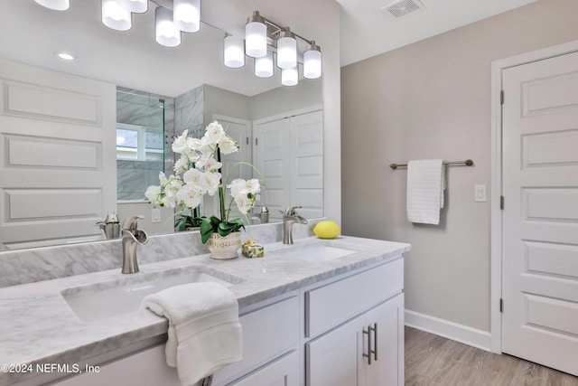 full bath with double vanity, a sink, visible vents, and baseboards