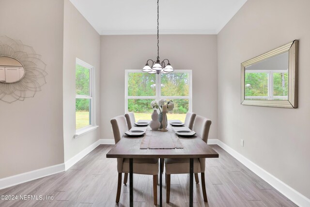 dining space featuring light wood-type flooring, a chandelier, and plenty of natural light