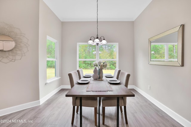 dining room featuring light wood-type flooring, baseboards, a chandelier, and a wealth of natural light