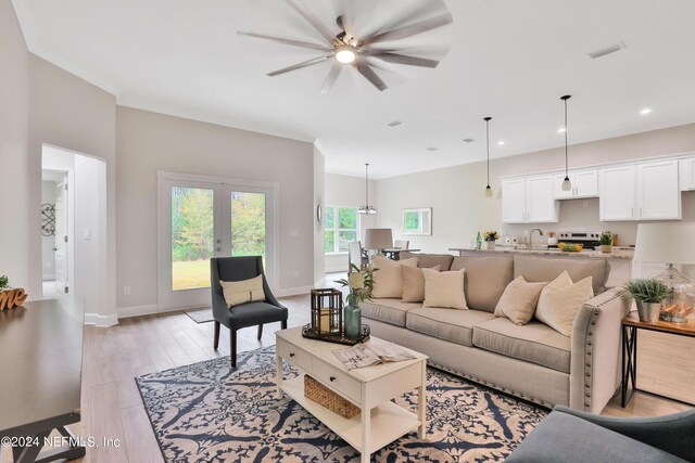 living room featuring ceiling fan, light wood-type flooring, and sink