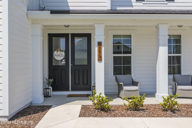 view of exterior entry featuring covered porch