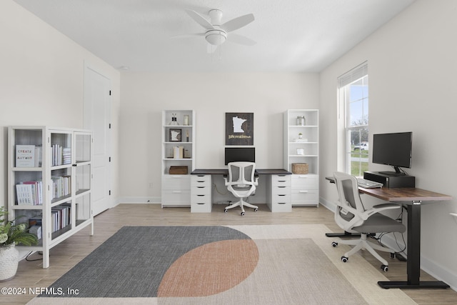 home office featuring baseboards, ceiling fan, and light wood finished floors