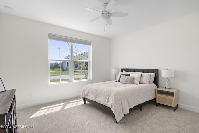 carpeted bedroom with baseboards and a ceiling fan