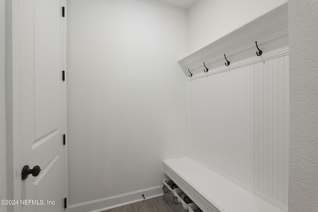 mudroom featuring dark wood-style flooring and baseboards