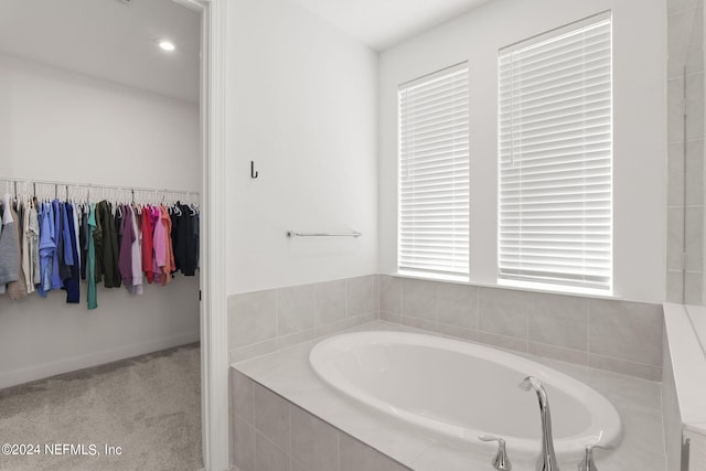 bathroom with a walk in closet and a bath