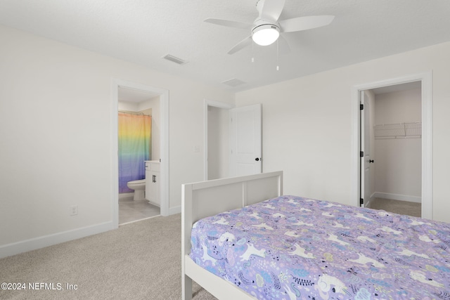 bedroom with visible vents, a spacious closet, carpet flooring, ensuite bath, and baseboards