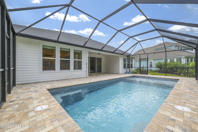 outdoor pool with a lanai and a patio area