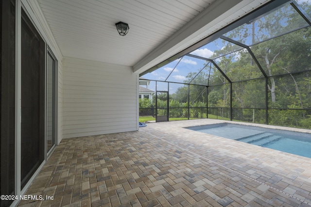 outdoor pool with glass enclosure and a patio