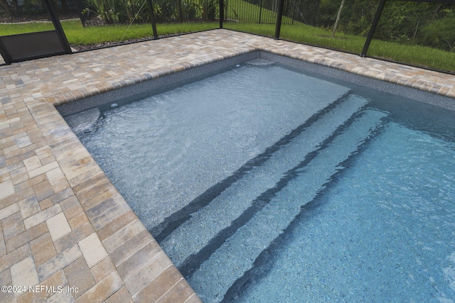 pool with a lanai and a patio