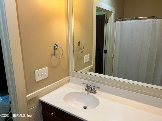 bathroom with vanity and tile walls