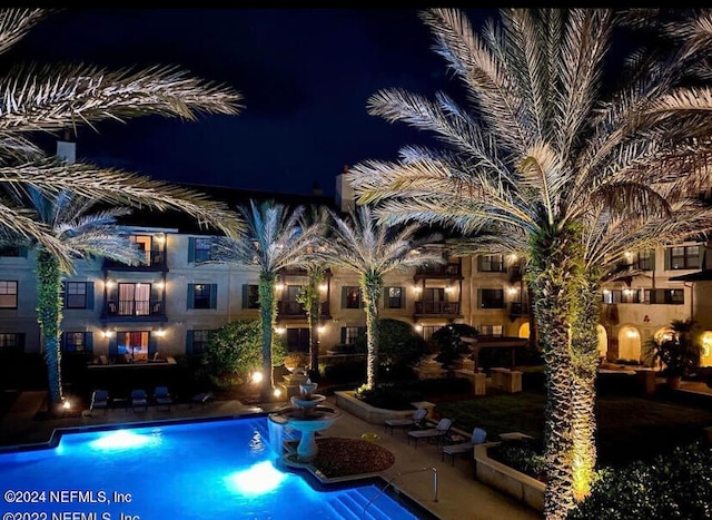 view of pool at twilight