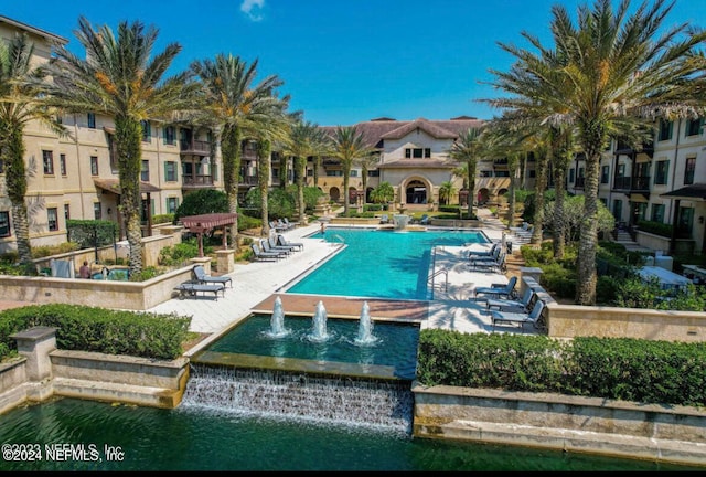 view of pool featuring pool water feature and a water view