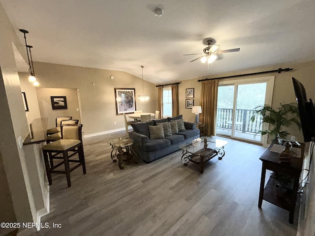 living room with lofted ceiling, hardwood / wood-style flooring, and ceiling fan