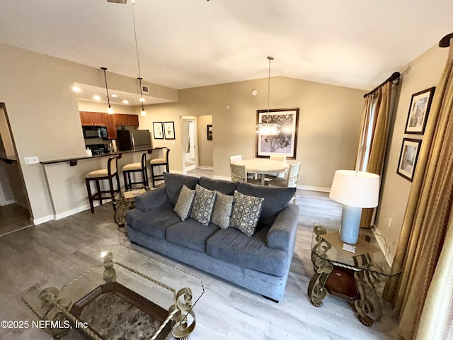 living room featuring lofted ceiling and hardwood / wood-style flooring