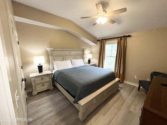 bedroom featuring ceiling fan, light hardwood / wood-style floors, and lofted ceiling