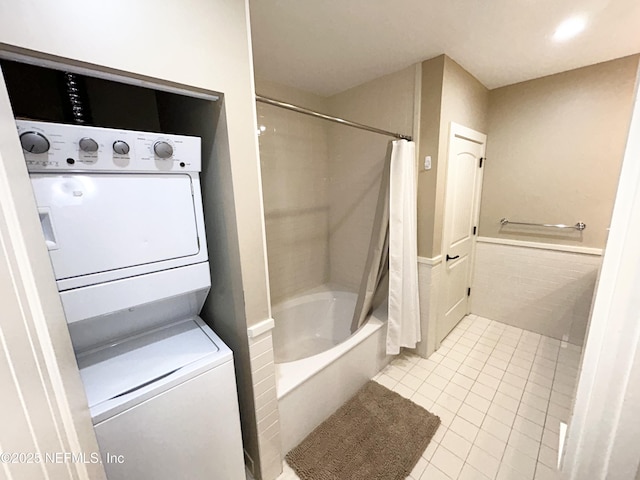 bathroom with tile patterned floors, shower / bathtub combination with curtain, and stacked washer / dryer