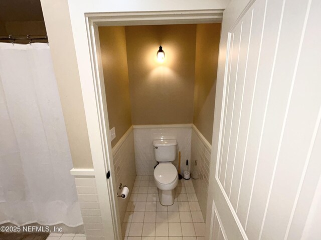 bathroom with tile walls, tile patterned flooring, and toilet