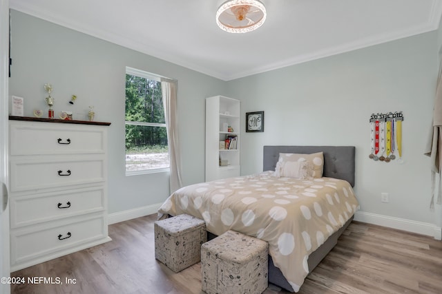 bedroom with light hardwood / wood-style floors and ornamental molding