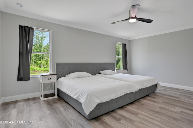 bedroom with light hardwood / wood-style floors, ceiling fan, and ornamental molding