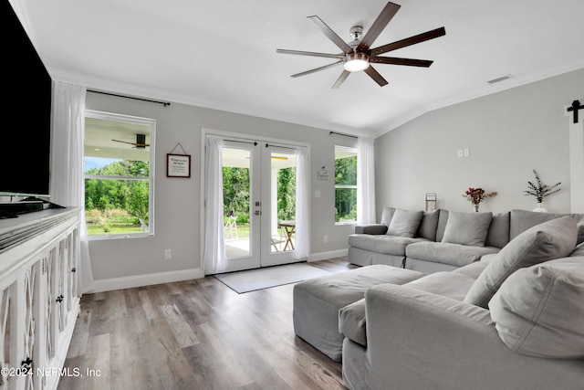 living room featuring french doors, ornamental molding, vaulted ceiling, and light wood-type flooring