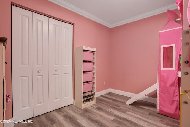 unfurnished bedroom featuring light hardwood / wood-style flooring, a closet, and ornamental molding