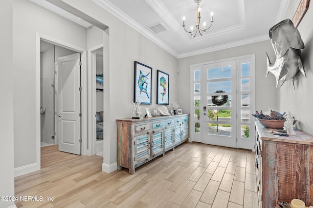 doorway featuring a raised ceiling, crown molding, light hardwood / wood-style flooring, and an inviting chandelier