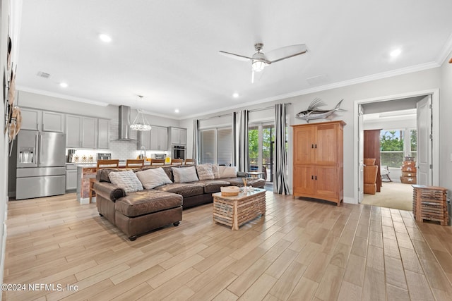 living room featuring ceiling fan with notable chandelier, light wood-type flooring, ornamental molding, and a wealth of natural light