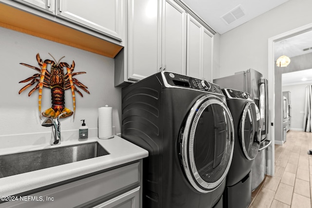 laundry room featuring cabinets and separate washer and dryer