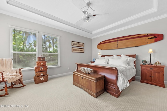 carpeted bedroom with a raised ceiling, ceiling fan, and ornamental molding