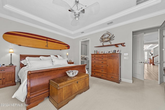 bedroom featuring ceiling fan, light colored carpet, crown molding, and a tray ceiling