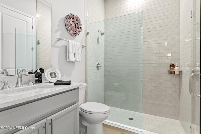 bathroom featuring hardwood / wood-style flooring, vanity, an enclosed shower, and toilet