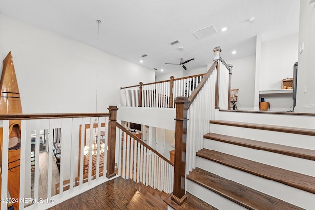 stairs with ceiling fan and hardwood / wood-style floors