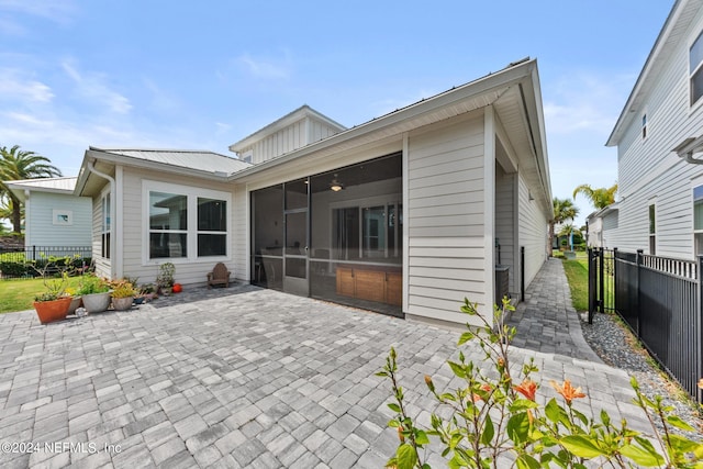 back of property with a patio area and a sunroom