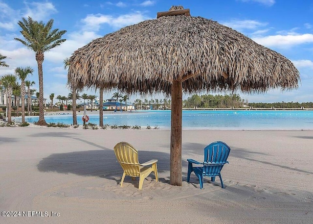 view of swimming pool featuring a gazebo, a view of the beach, and a water view