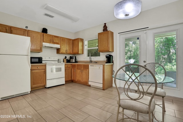 kitchen with white appliances, sink, and light tile floors