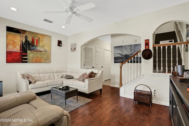 living room featuring ceiling fan and dark wood-type flooring