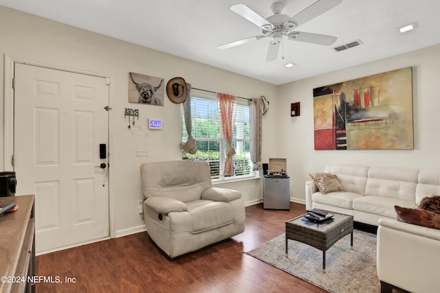 living room featuring ceiling fan and dark wood-type flooring