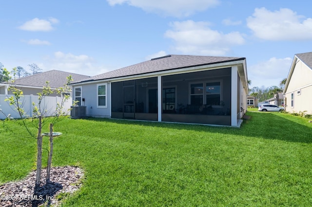 back of property featuring a sunroom, a lawn, and central AC unit