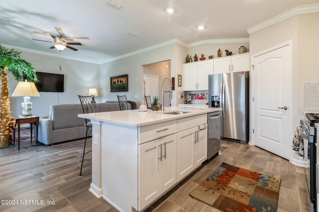 kitchen with stainless steel appliances, wood tiled floor, visible vents, and a sink