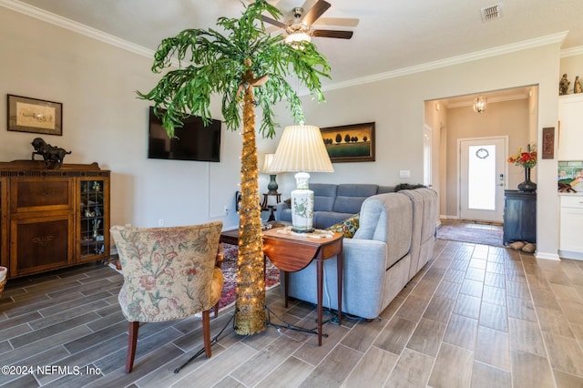 living room with crown molding, visible vents, a ceiling fan, and wood tiled floor