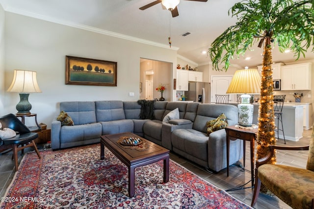 living room with visible vents, ceiling fan, wood finished floors, vaulted ceiling, and crown molding