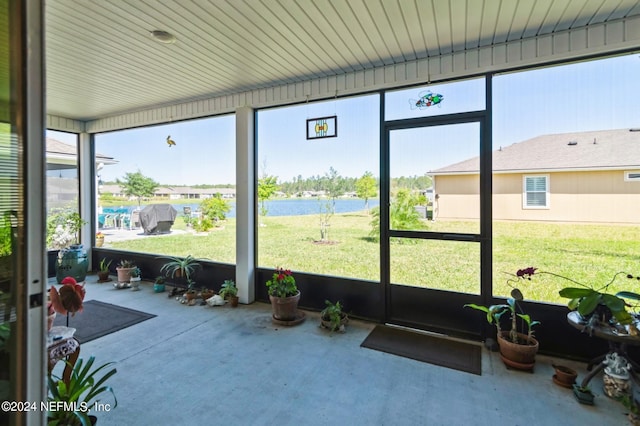 sunroom / solarium featuring a healthy amount of sunlight and a water view