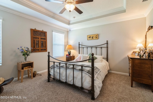 carpeted bedroom featuring a ceiling fan, a raised ceiling, crown molding, and baseboards