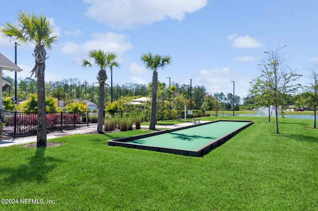 view of community with fence and a yard