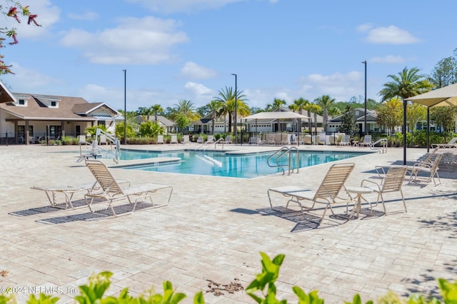 community pool featuring a patio and fence